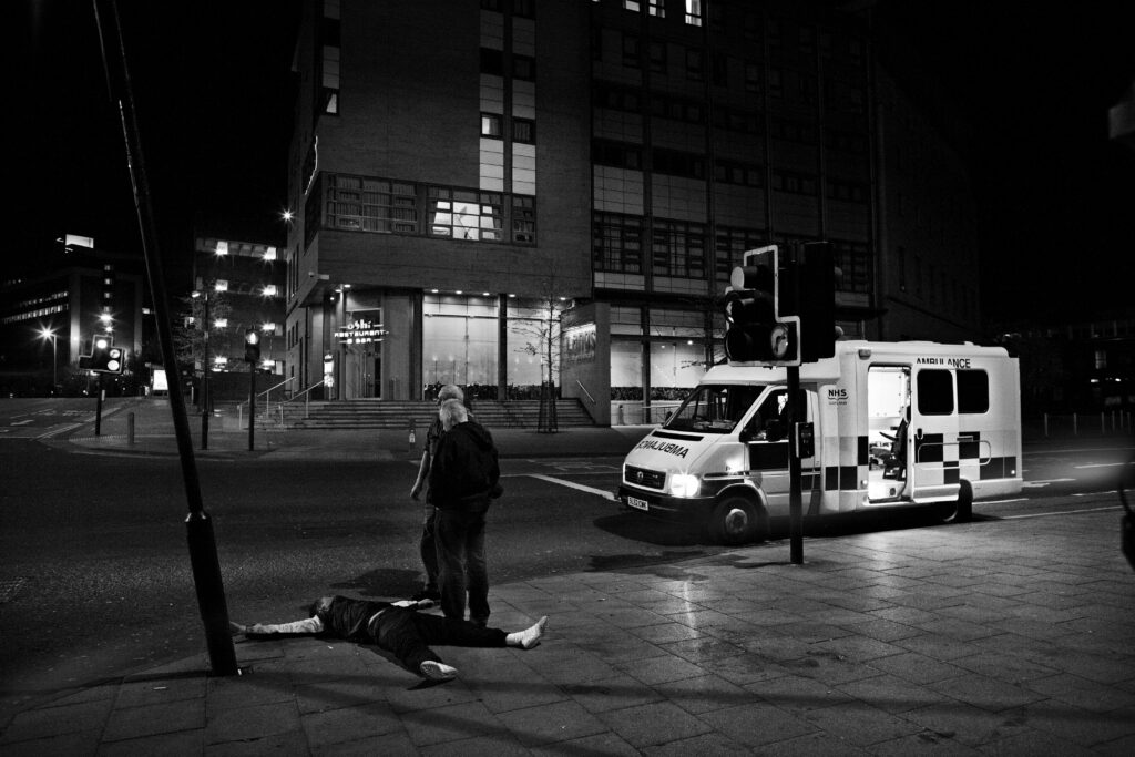 Paramedics attend to a man knocked out in a street fight in Glasgow city centre, Scotland