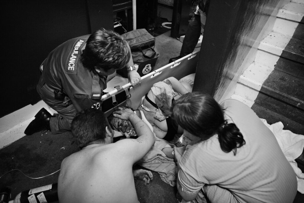 Paramedics attend to an elderly woman who has been beaten unconscious by a gang of teenage girls in Glasgow, Scotland