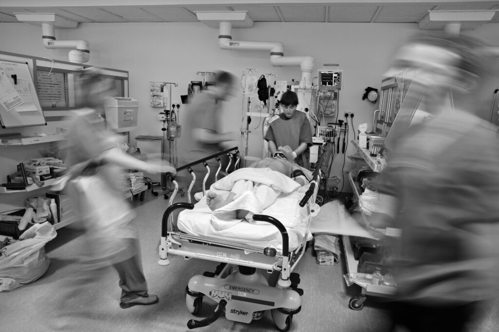 Hospital staff blur as they rush past the body of a young man suffering horrific head injuries following a gang related attack in Glasgow, Scotland.