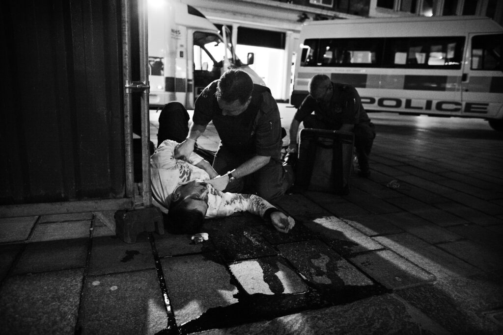Paramedics attend to a man bleeding on the street following a violent attack in Glasgow city centre.